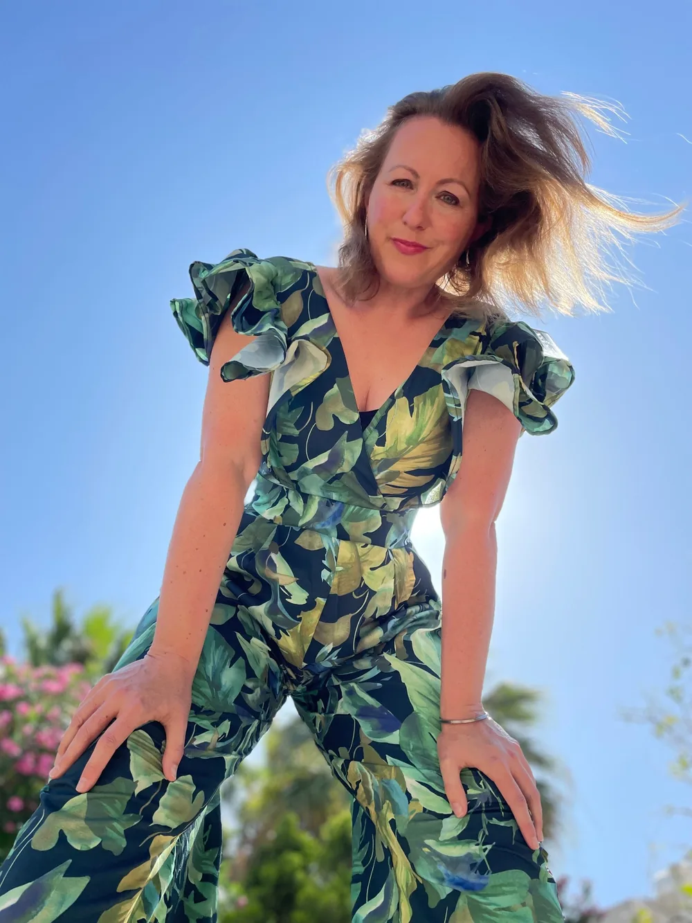 Catherine laughing in the sun in a leaf-print jumpsuit