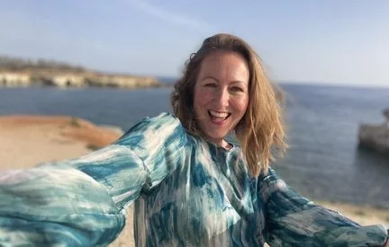 Catherine smiling on a beach