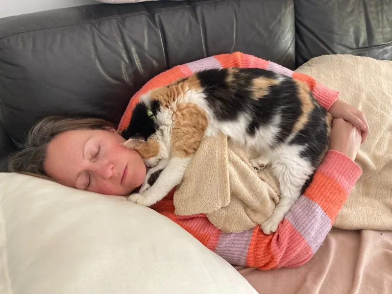 Catherine resting in bed with her cat Madeleine